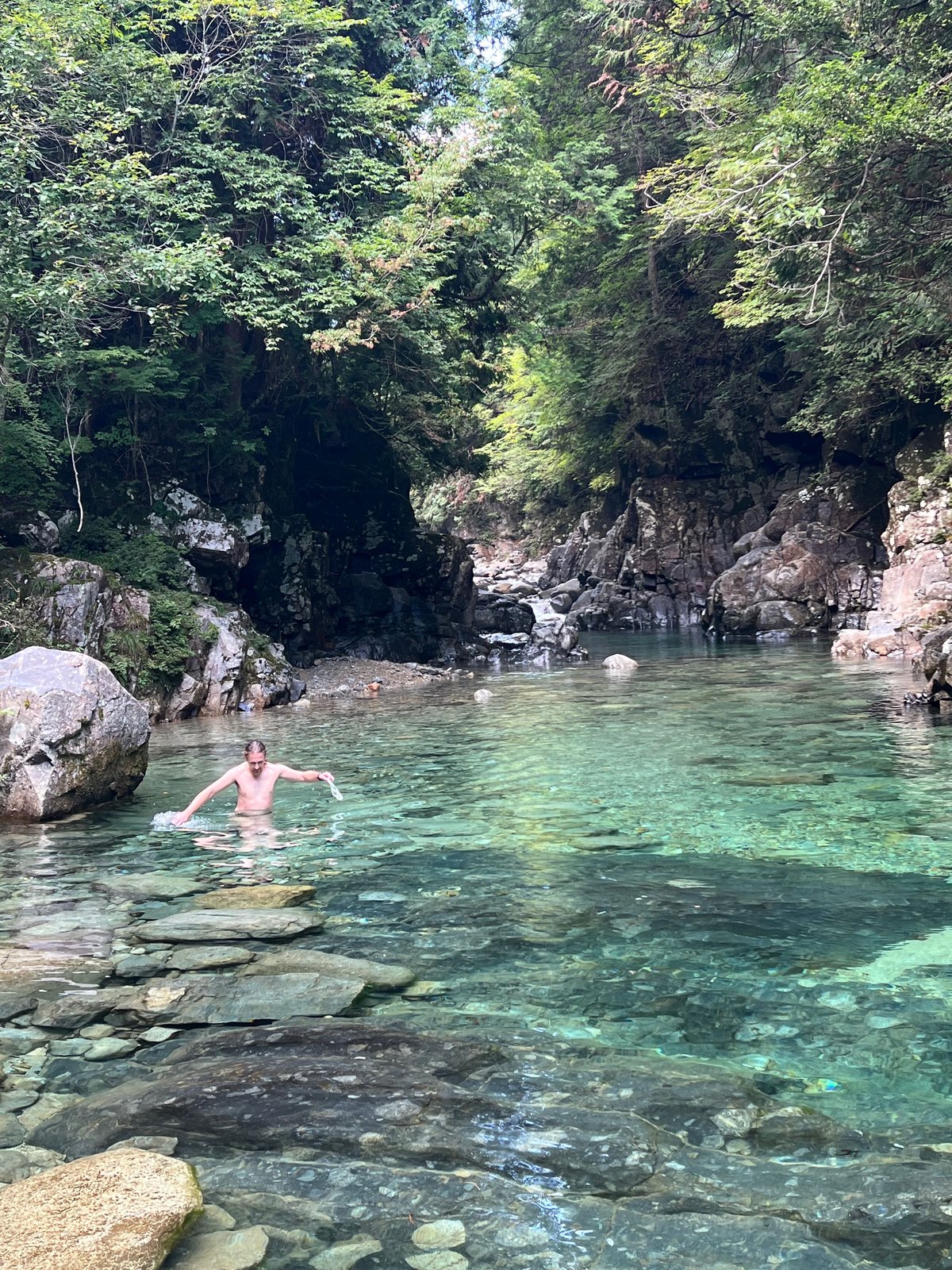 A swimmer in the brilliant emerald-green water of an Atera Valley pool