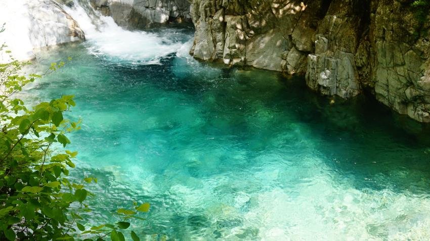 A small waterfall feeding a vivid turquoise pool in Atera Valley