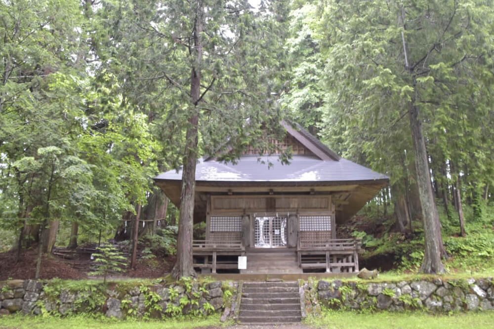 Hinomikosha Shrine's small wooden hall, tucked among tall cedar trees
