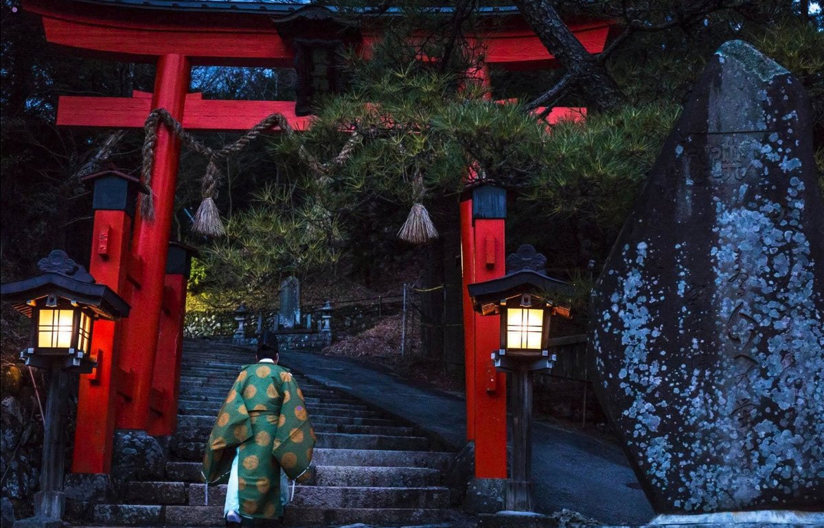A visitor in kimono climbing the steps beneath the red torii gate of Yabuhara Shrine