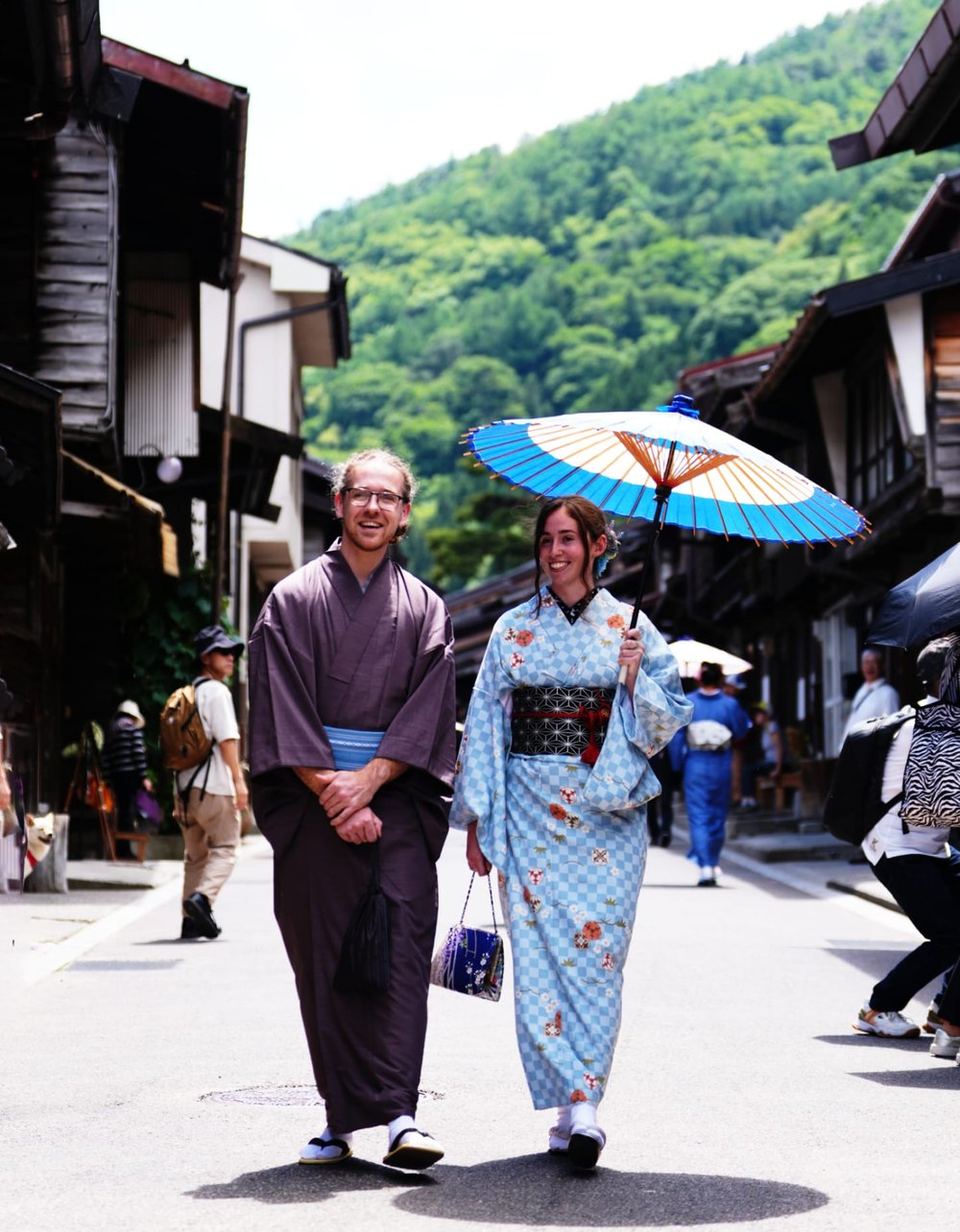 A couple in kimono walking the streets of Narai-juku with a wagasa umbrella